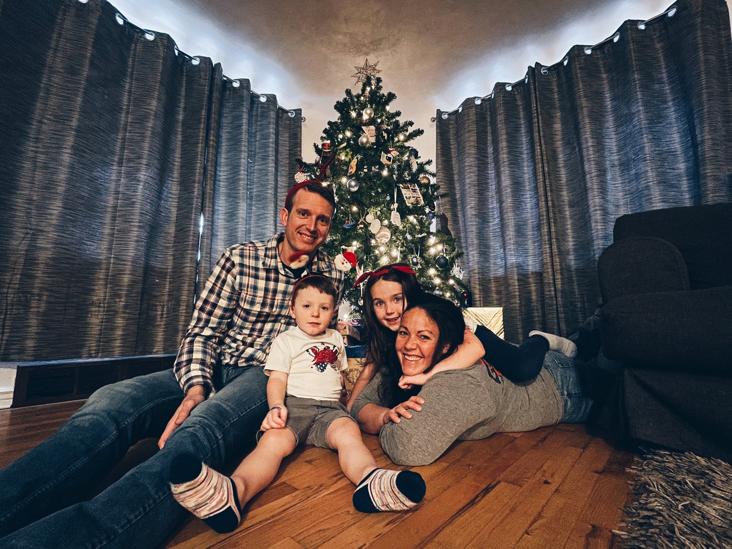 Clayton and Bridgett Borah with their family sitting together by a Christmas tree