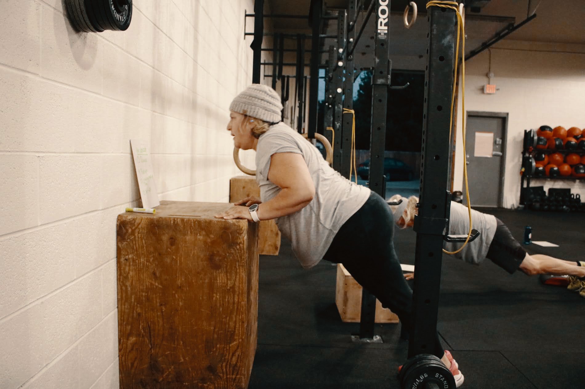 Member performing a push-up during a one-on-one coaching session at Timber & Steel