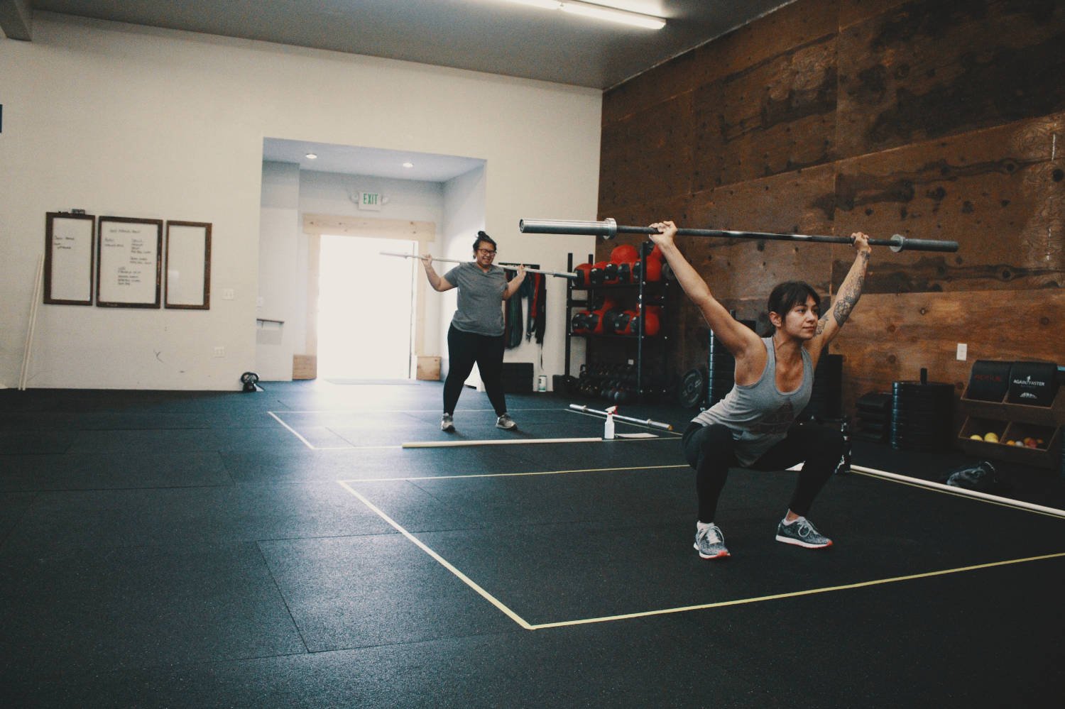 Two members training with barbells at Timber & Steel